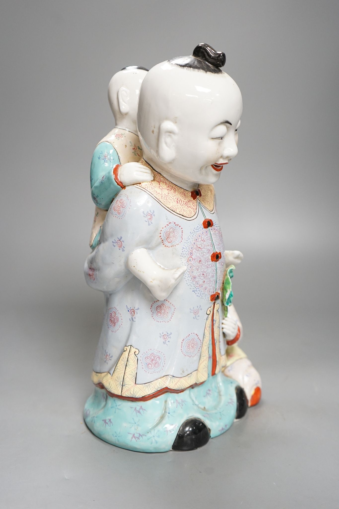 A large Chinese enamelled porcelain boys group, 31cm